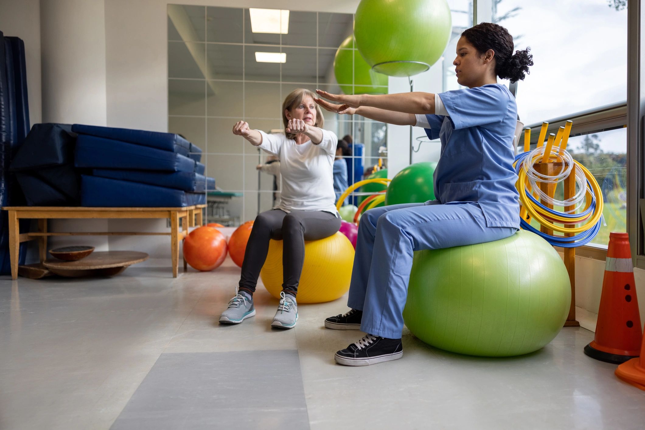 Physical therapist assisting senior with mobility exercises